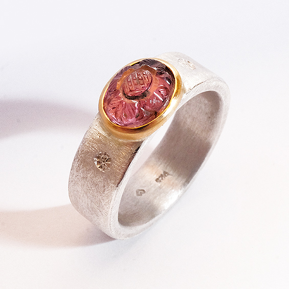 Blütenpracht Ring aus Silber mit goldenen Akzenten und einem bunten, runden Edelstein.